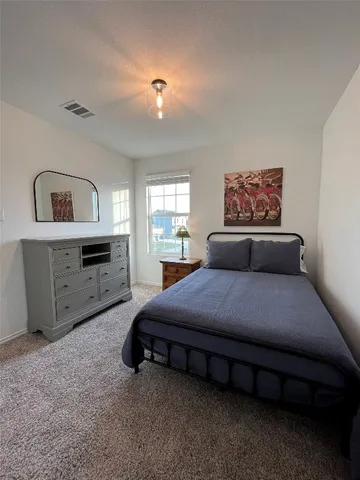 a bedroom with a bed and a dresser