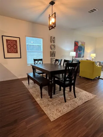a view of a dining room with furniture wooden floor and chandelier