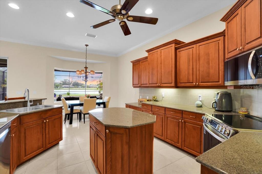 3336 Lakeside Circle Parrish, FL 34219 - Photo 16 of 49 a kitchen with kitchen island granite countertop a sink counter top space appliances and cabinets