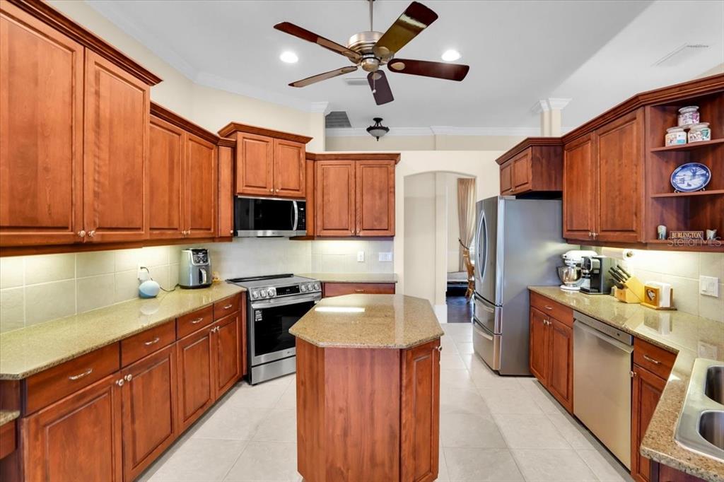 3336 Lakeside Circle Parrish, FL 34219 - Photo 18 of 49 a kitchen with stainless steel appliances granite countertop a sink dishwasher stove top oven and refrigerator with wooden cabinets