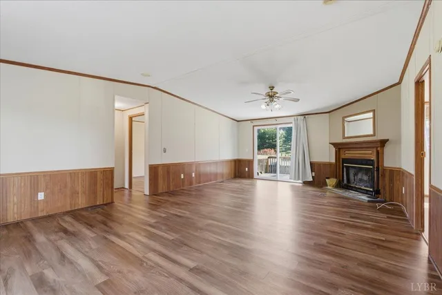 a view of empty room with wooden floor and fireplace