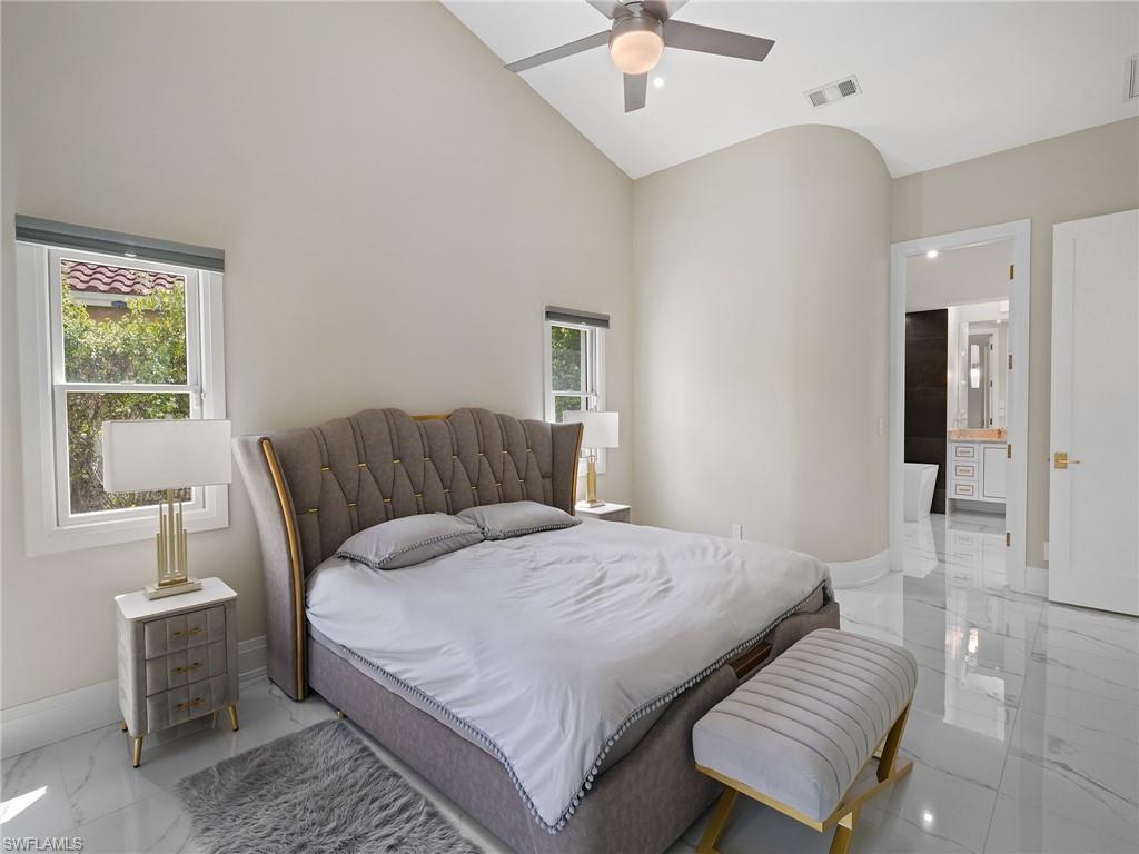 2140 Harlans Run Naples, FL 34105 - Photo 19 of 37 a bedroom with a bed and a chandelier