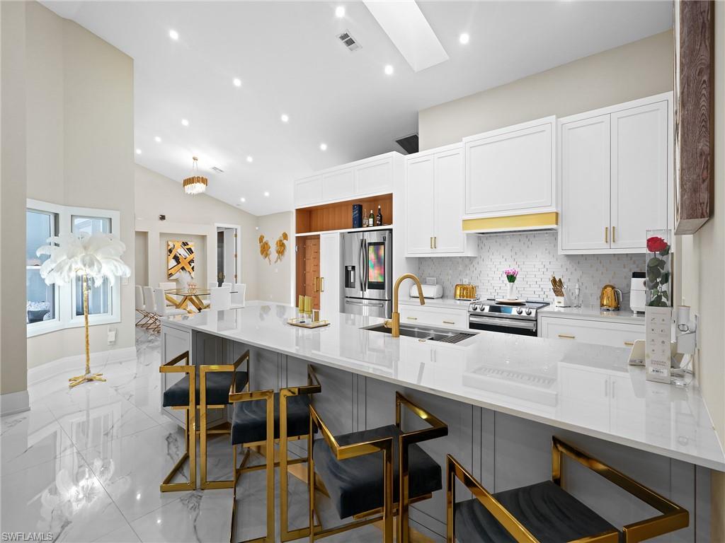 2140 Harlans Run Naples, FL 34105 - Photo 2 of 37 a kitchen with stainless steel appliances a table chairs refrigerator and cabinets