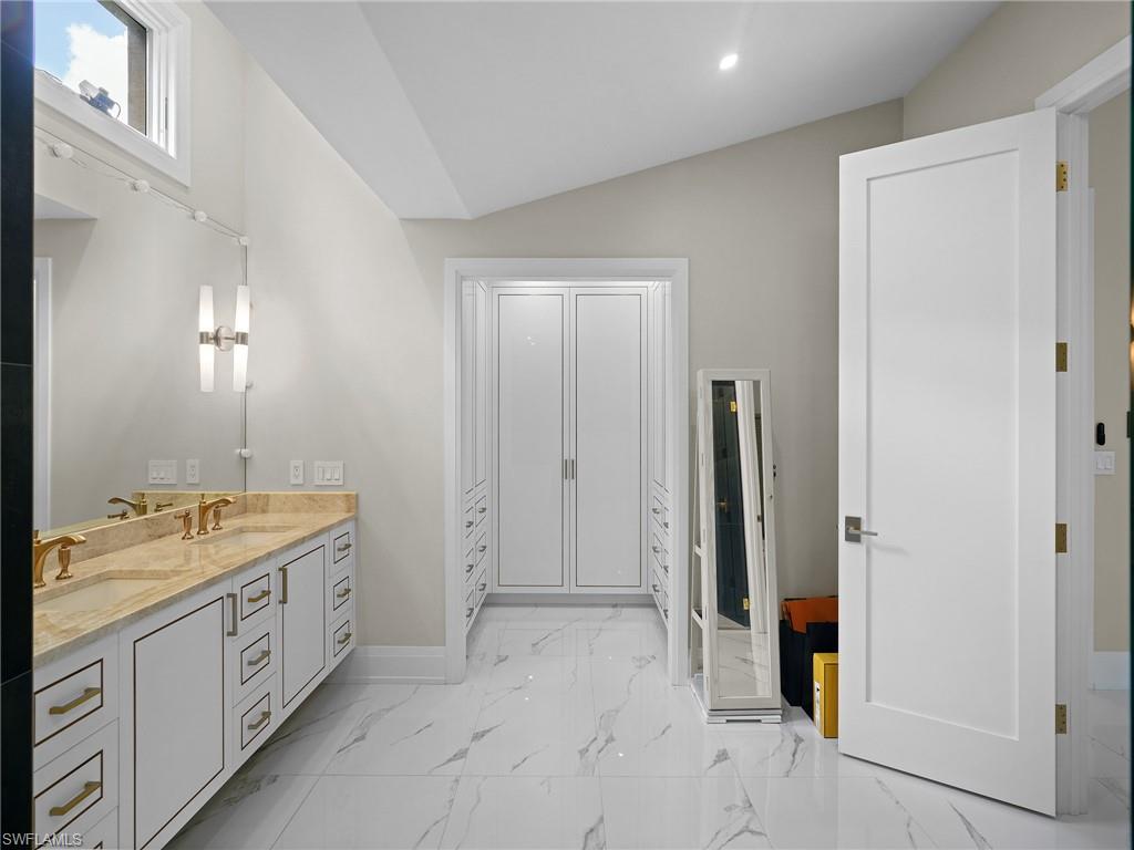 2140 Harlans Run Naples, FL 34105 - Photo 22 of 37 a spacious bathroom with a double vanity sink a large mirror and a shower