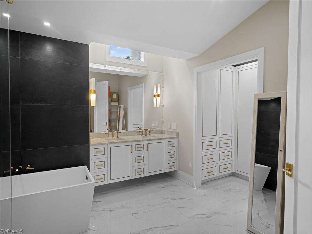 2140 Harlans Run Naples, FL 34105 - Photo 23 of 37 a bathroom with a granite countertop sink a tub and a mirror