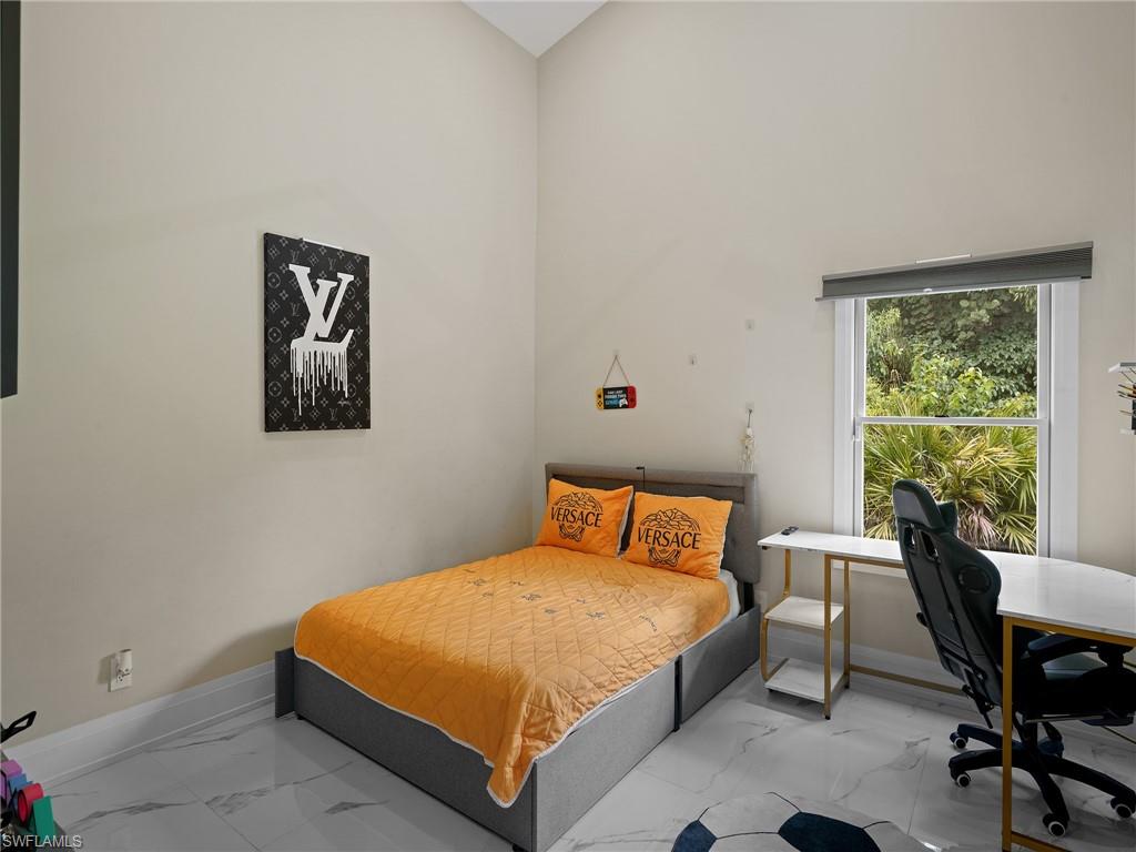 2140 Harlans Run Naples, FL 34105 - Photo 27 of 37 a bedroom with a bed a table and chair