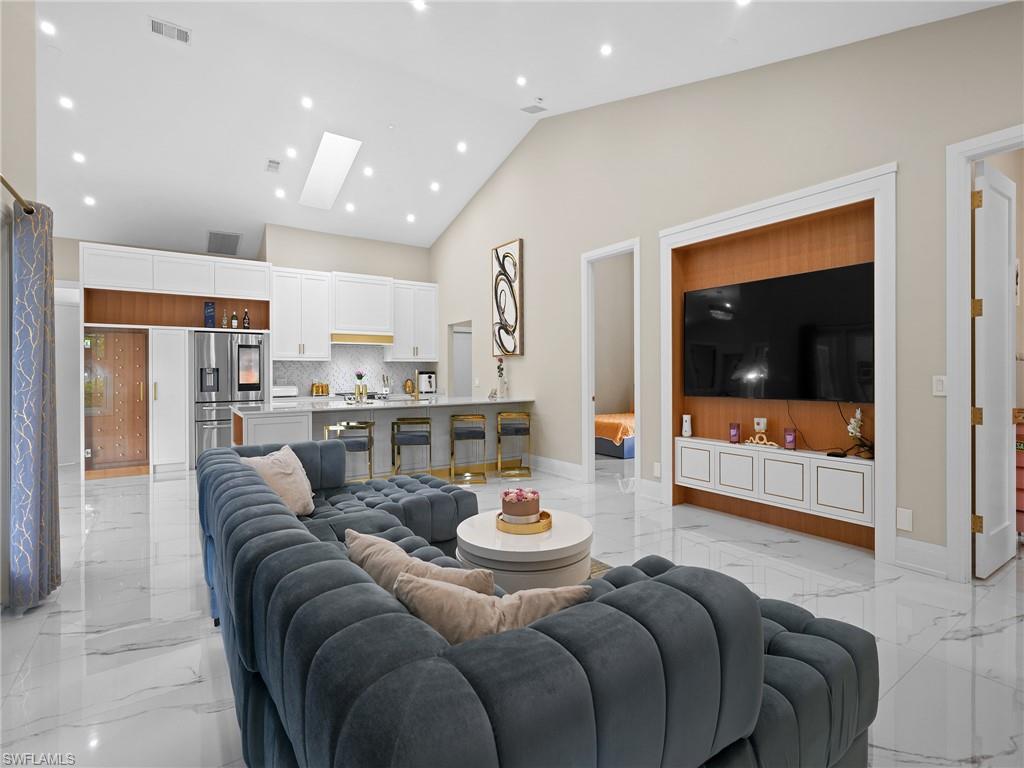 2140 Harlans Run Naples, FL 34105 - Photo 3 of 37 a living room with stainless steel appliances furniture a rug and a kitchen view