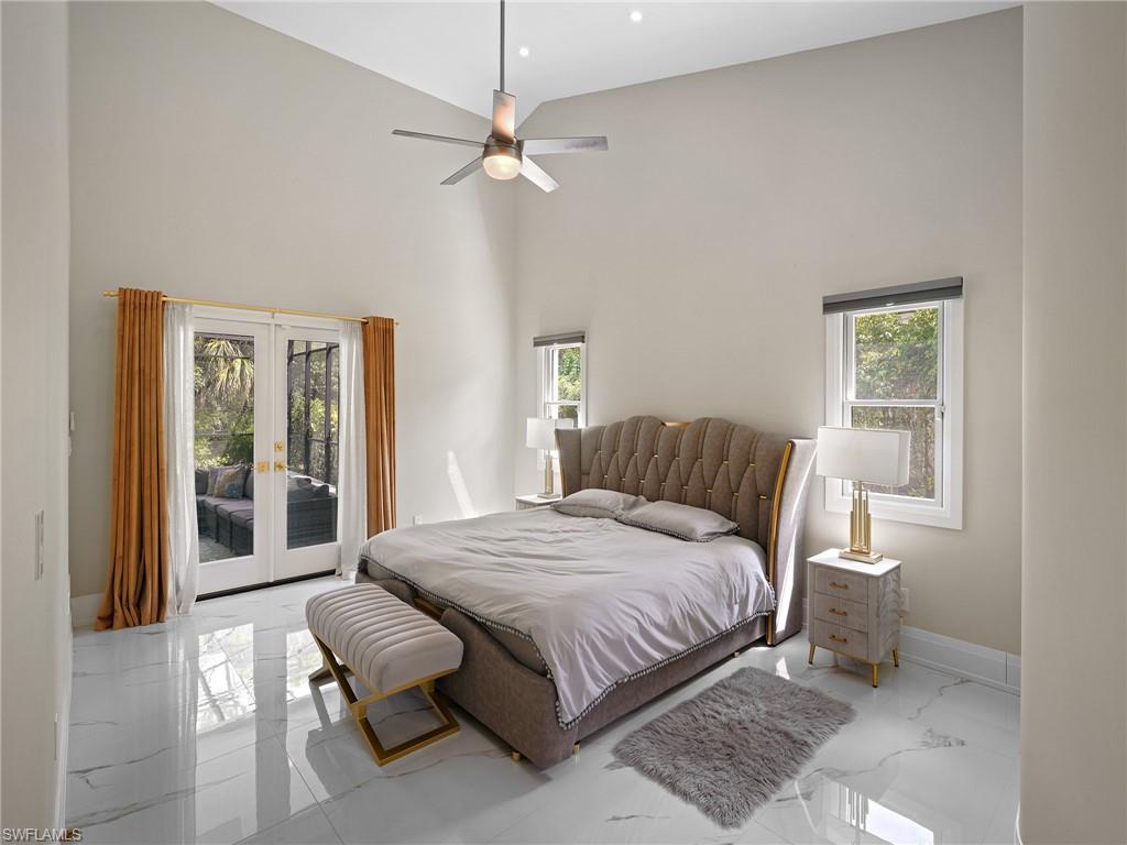 2140 Harlans Run Naples, FL 34105 - Photo 6 of 37 a bedroom with a large bed and a chandelier