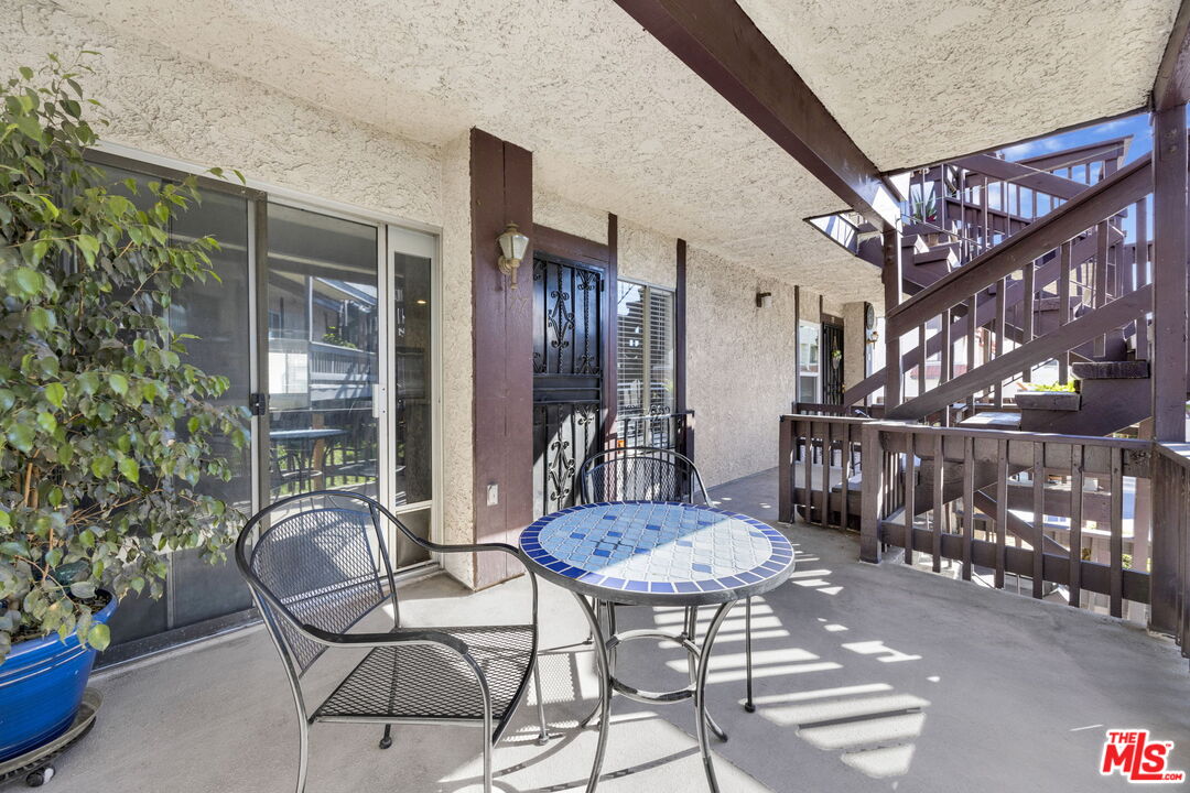 12330 Osborne Street, Unit 77 Pacoima, CA 91331 - Photo 2 of 32 a view of a patio with table and chairs with wooden floor and plants