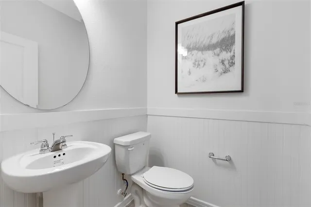 a bathroom with a toilet sink and mirror