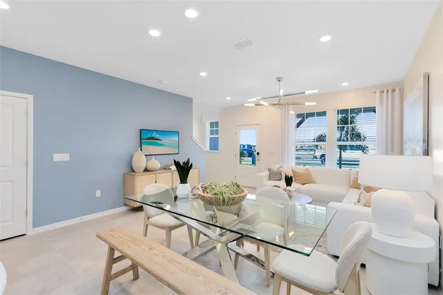 a living room with furniture and a dining table with wooden floor