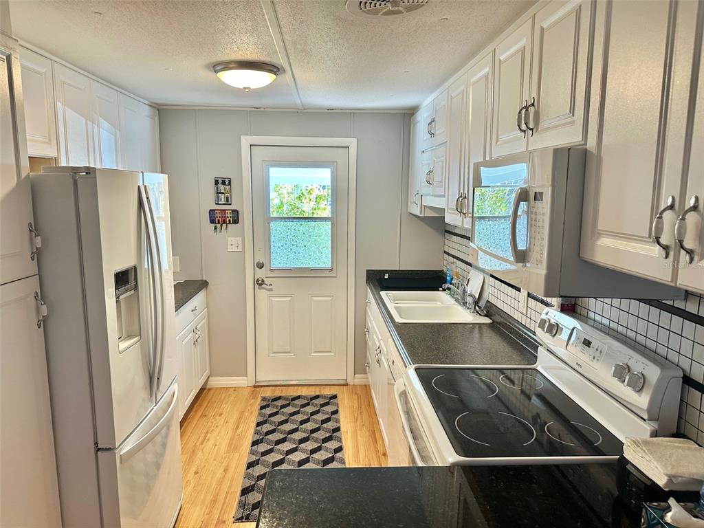 9900 Ulmerton Road, Unit 61 Largo, FL 33771 - Photo 3 of 17 a kitchen with stainless steel appliances granite countertop a refrigerator and a stove