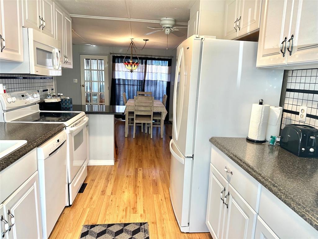 9900 Ulmerton Road, Unit 61 Largo, FL 33771 - Photo 4 of 17 a kitchen with stainless steel appliances granite countertop a refrigerator a stove and a wooden floors