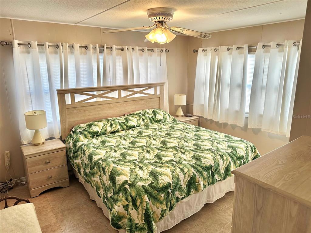 9900 Ulmerton Road, Unit 61 Largo, FL 33771 - Photo 7 of 17 a bed sitting in a bedroom next to a window and a chandelier