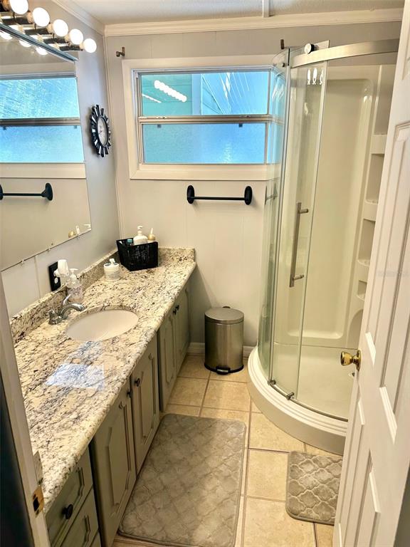 9900 Ulmerton Road, Unit 61 Largo, FL 33771 - Photo 8 of 17 a bathroom with a granite countertop sink a mirror and shower