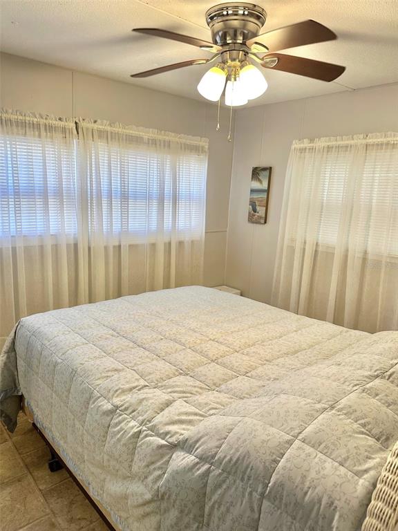 9900 Ulmerton Road, Unit 61 Largo, FL 33771 - Photo 10 of 17 a bedroom with a bed and a chandelier