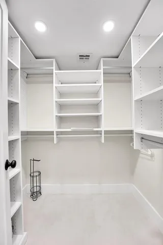 a view of walk in closet with empty racks