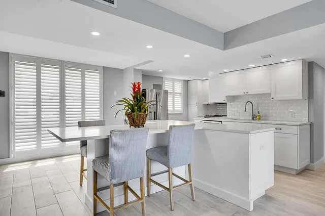 a kitchen with kitchen island a stove a table and chairs in it