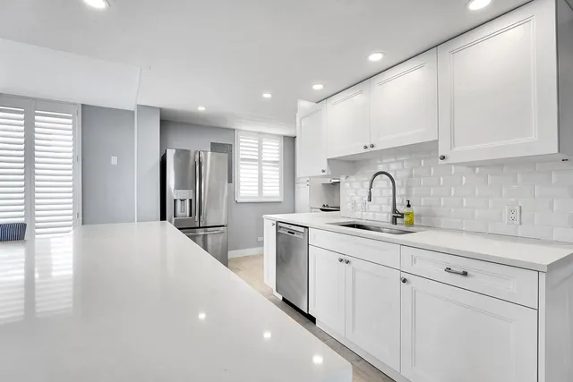 a kitchen with sink a refrigerator and cabinets