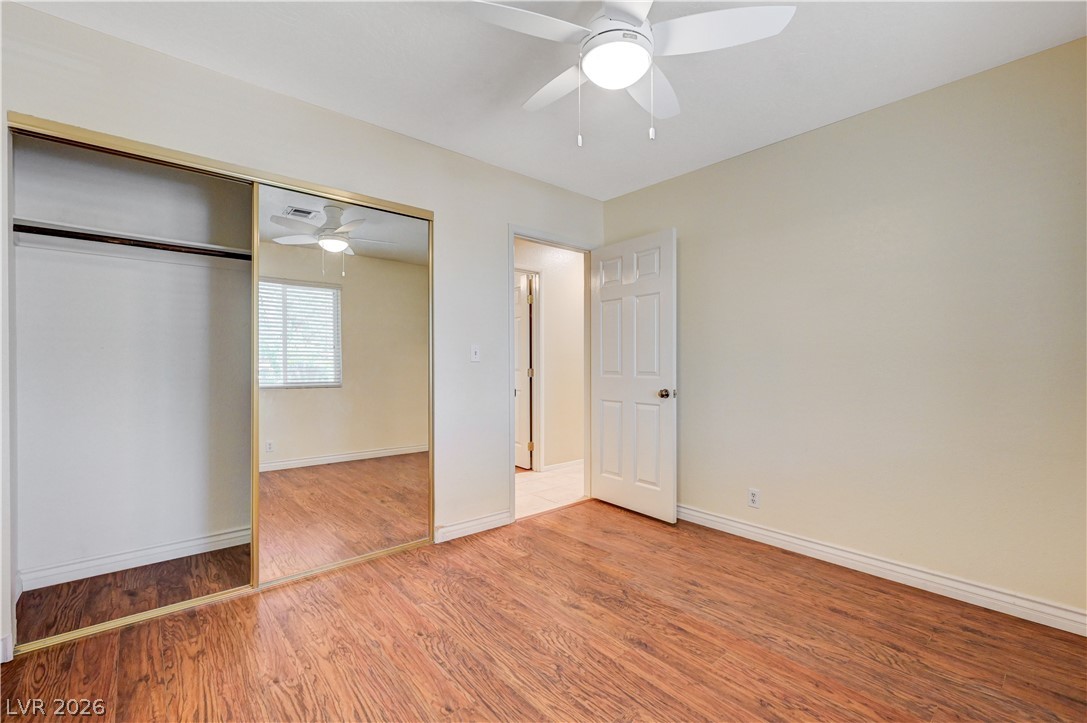 7631 Bermuda Road Las Vegas, NV 89123 - Photo 25 of 64 A well-lit room featuring rich wood flooring and a mirrored closet for an open feel.