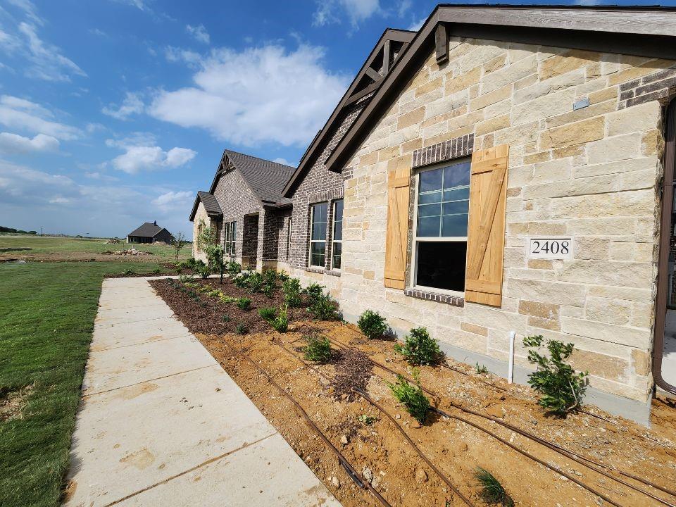 2408 Quartz Street Krum, TX 76249 - Photo 4 of 16 a front view of a house with garden