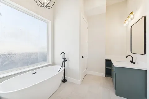 a bathroom with a tub sink and mirror