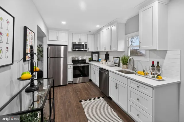 a kitchen with stainless steel appliances a refrigerator sink and white cabinets
