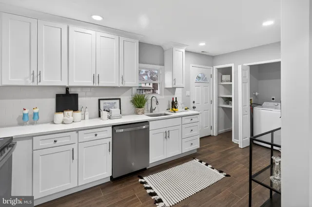 a kitchen with white cabinets and appliances
