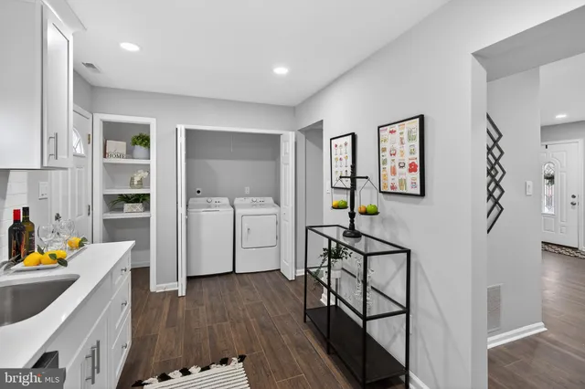 a view of a hallway with workspace and wooden floor