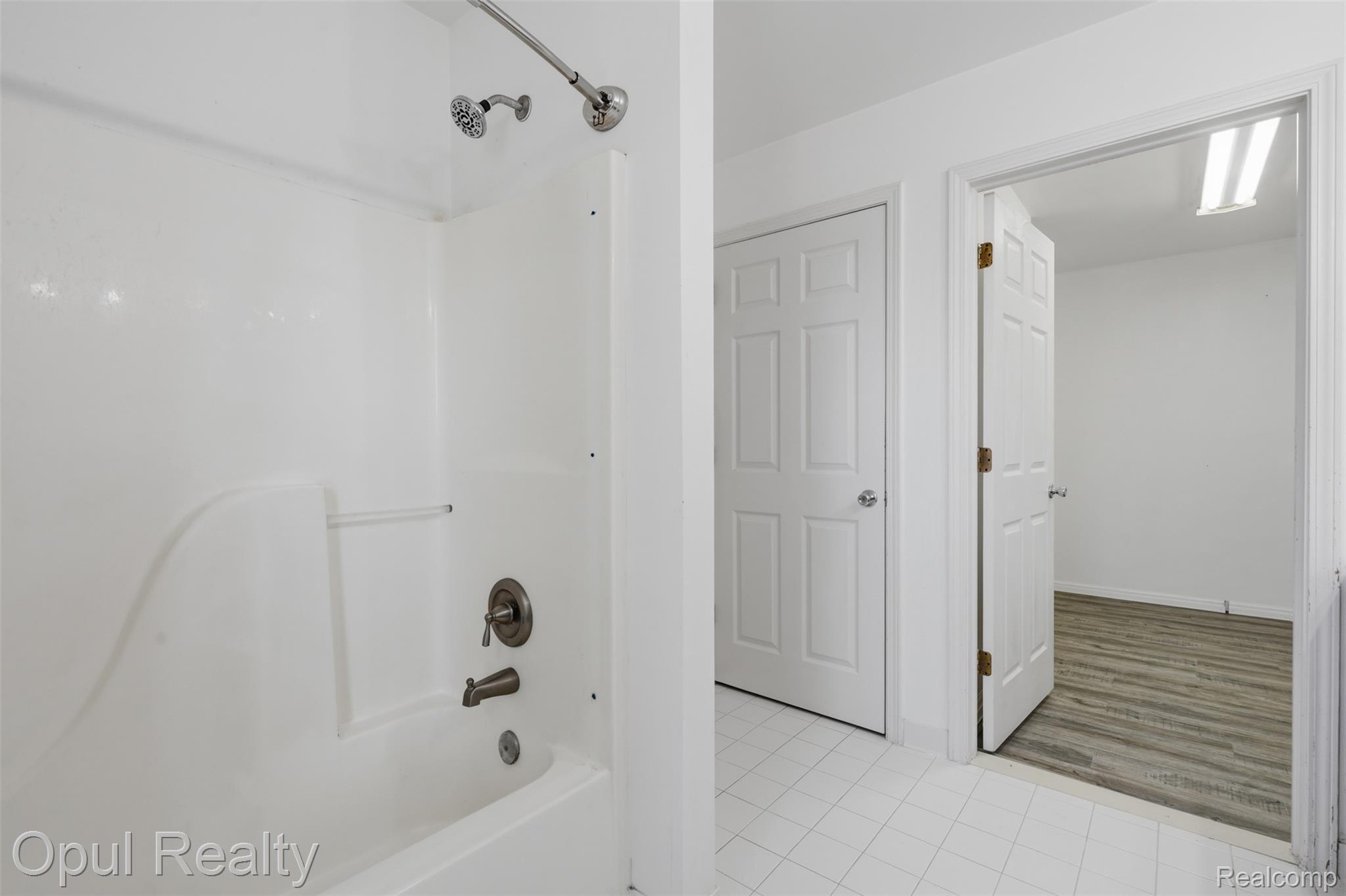 4530 Pond Run Canton, MI 48188 - Photo 27 of 43 White tiled flooring in this bathroom, featuring a tub/shower combination with a brushed nickel fixture