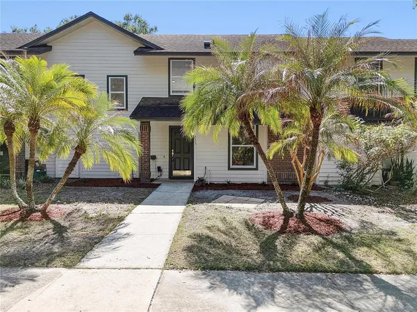 a palm tree sitting in front of a house