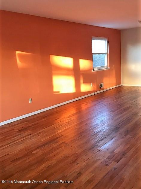534 Line Road Hazlet, NJ 07730 - Photo 4 of 21 a view of an empty room with wooden floor and a window
