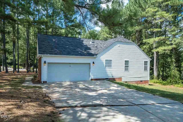 a view of a house with a yard and large tree