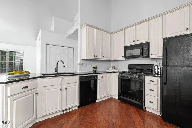 a kitchen with granite countertop a sink cabinets and stainless steel appliances