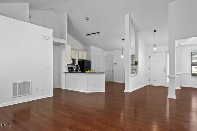 a view of a kitchen with wooden floor and electronic appliances