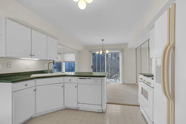 a kitchen with white cabinets and sink
