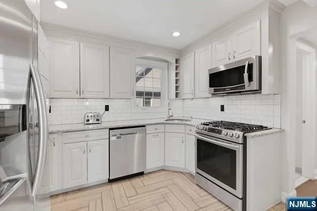 a kitchen with stainless steel appliances granite countertop a stove microwave and sink