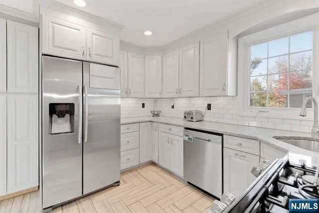 a kitchen with a refrigerator sink and cabinets