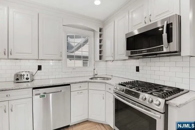 a kitchen with stainless steel appliances a sink dishwasher stove and microwave