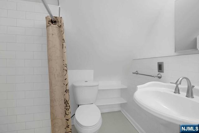 23 Donaldson Avenue, Unit 2 Rutherford, NJ 07070 - Photo 28 of 32 a white toilet sitting next to a bathroom sink