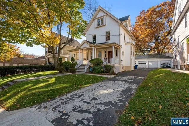 a front view of a house with a garden and trees