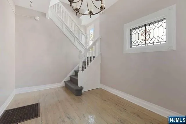 a view of entryway and hall with wooden floor