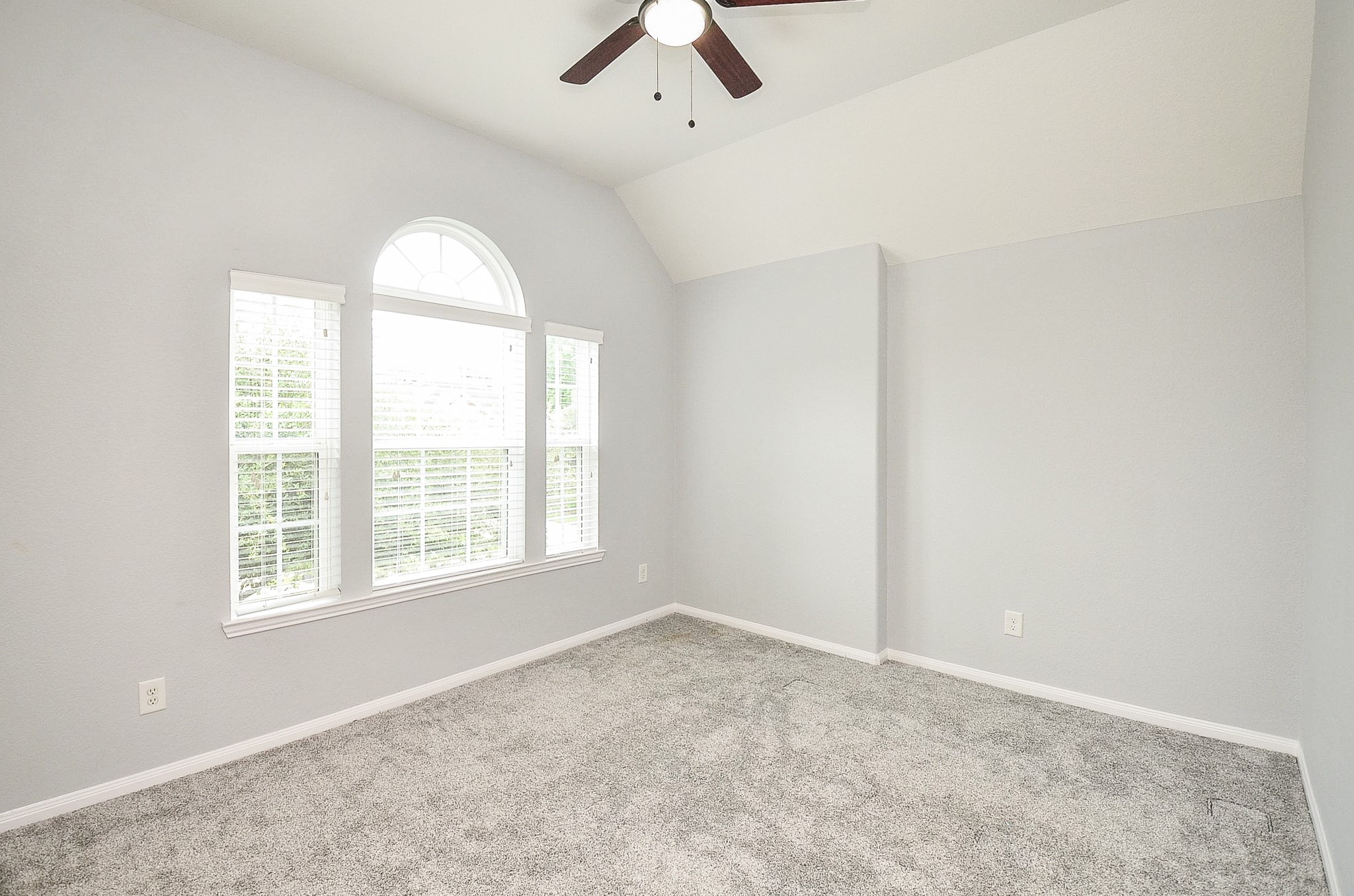 7042 Sliding Rock Circle Spring, TX 77379 - Photo 22 of 36 Here's a compelling and concise description for the photo:
"Bright and inviting bedroom with elegant arched window and plush carpeting.