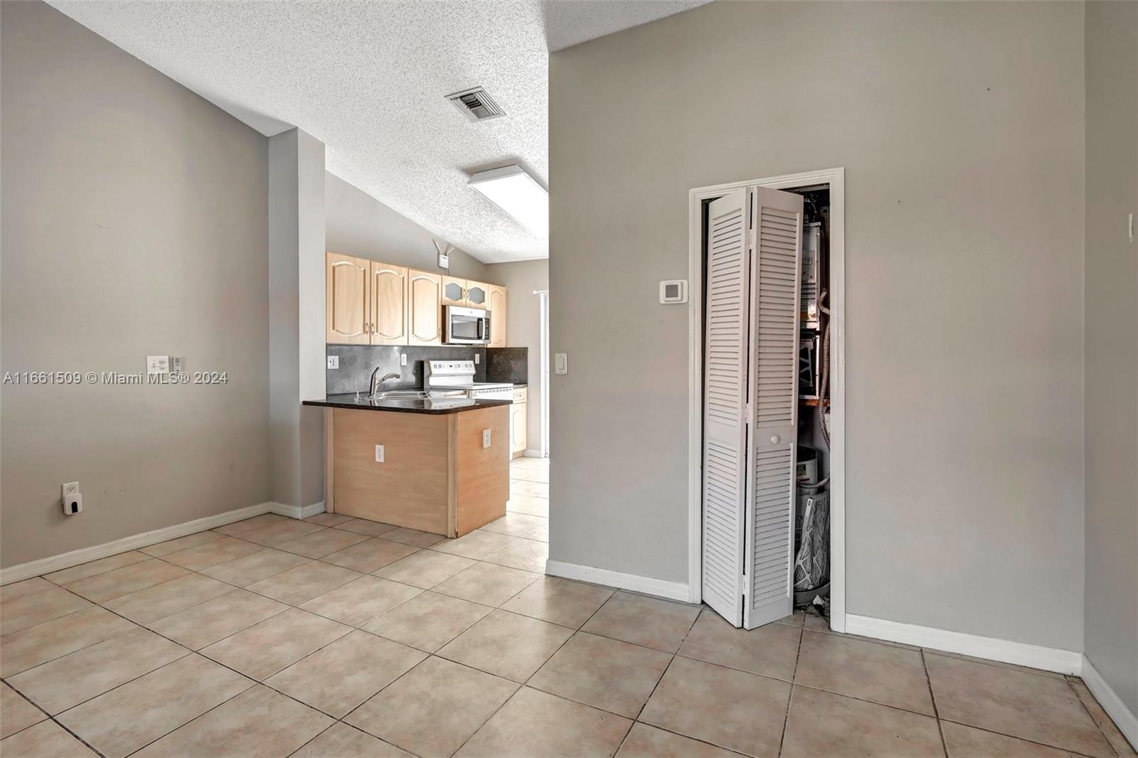 2527 West 76th Street, Unit 208 Hialeah, FL 33016 - Photo 11 of 37 a view of kitchen with refrigerator and window