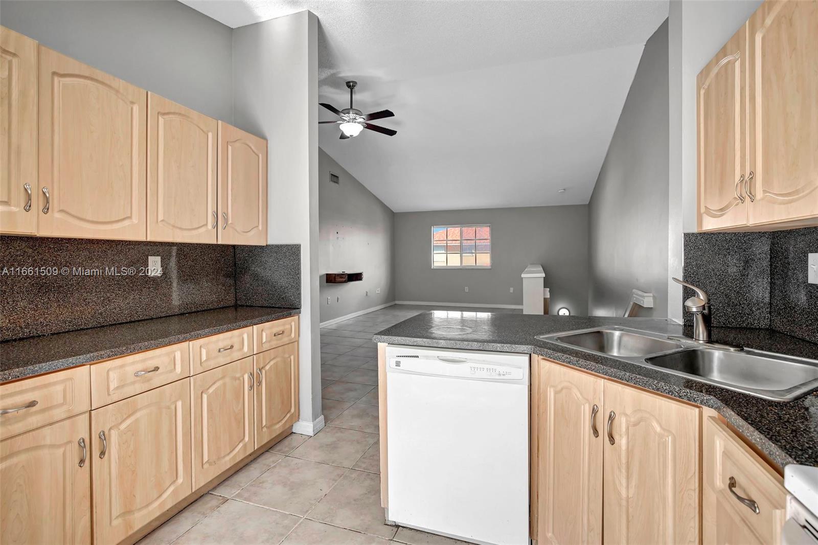 2527 West 76th Street, Unit 208 Hialeah, FL 33016 - Photo 15 of 37 a kitchen with granite countertop a sink stove and cabinets