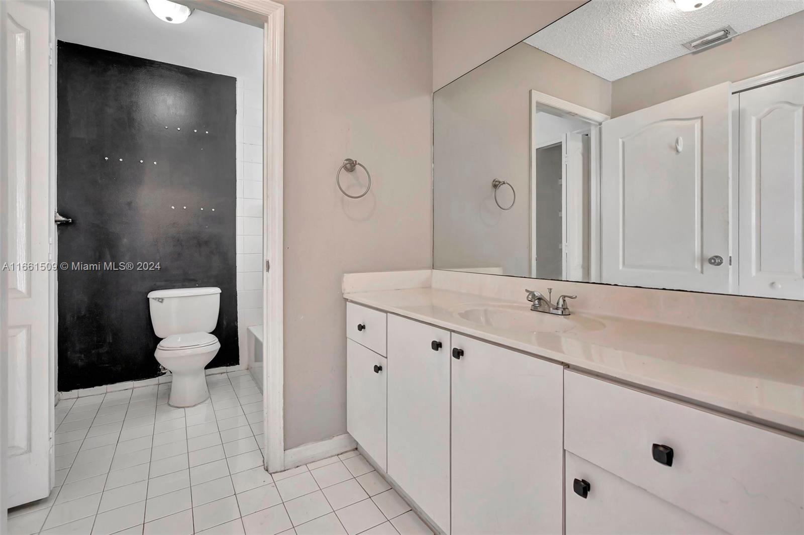 2527 West 76th Street, Unit 208 Hialeah, FL 33016 - Photo 26 of 37 a bathroom with a sink a toilet and a mirror