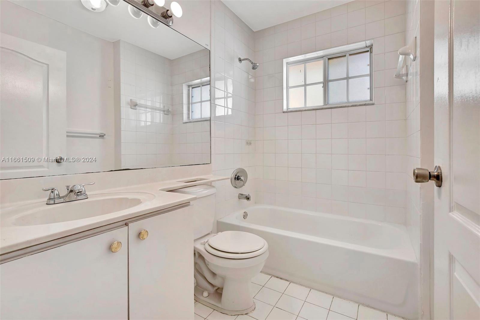 2527 West 76th Street, Unit 208 Hialeah, FL 33016 - Photo 28 of 37 a bathroom with a granite countertop sink a toilet and shower