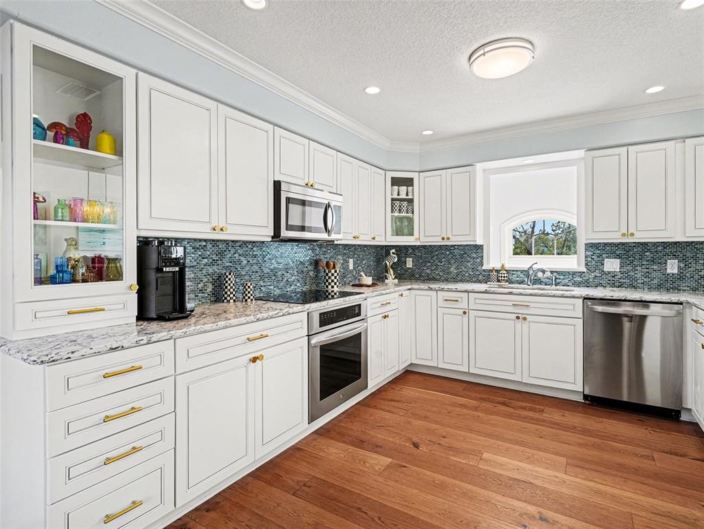 129 Hammock Road Anna Maria, FL 34216 - Photo 11 of 52 a kitchen with stainless steel appliances granite countertop a stove a sink and white cabinets
