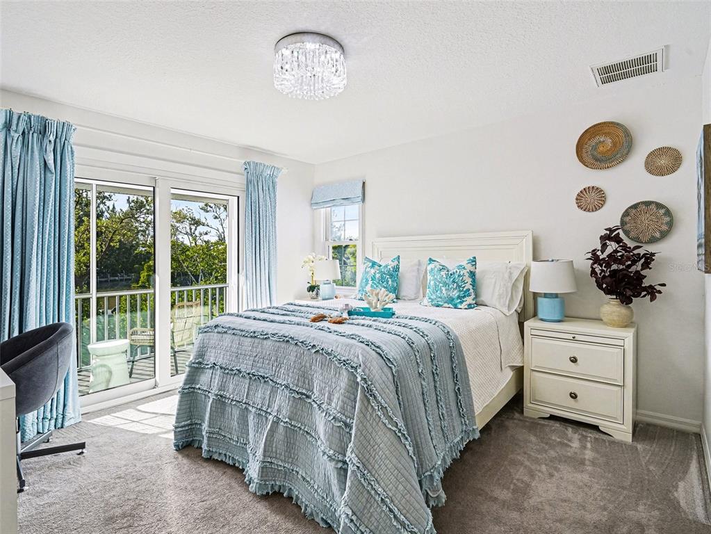 129 Hammock Road Anna Maria, FL 34216 - Photo 19 of 52 a bedroom with a bed and a chandelier