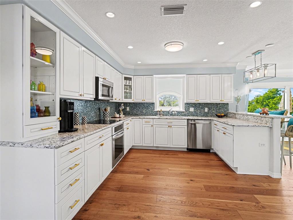 129 Hammock Road Anna Maria, FL 34216 - Photo 7 of 52 a kitchen with stainless steel appliances granite countertop a white cabinets and window